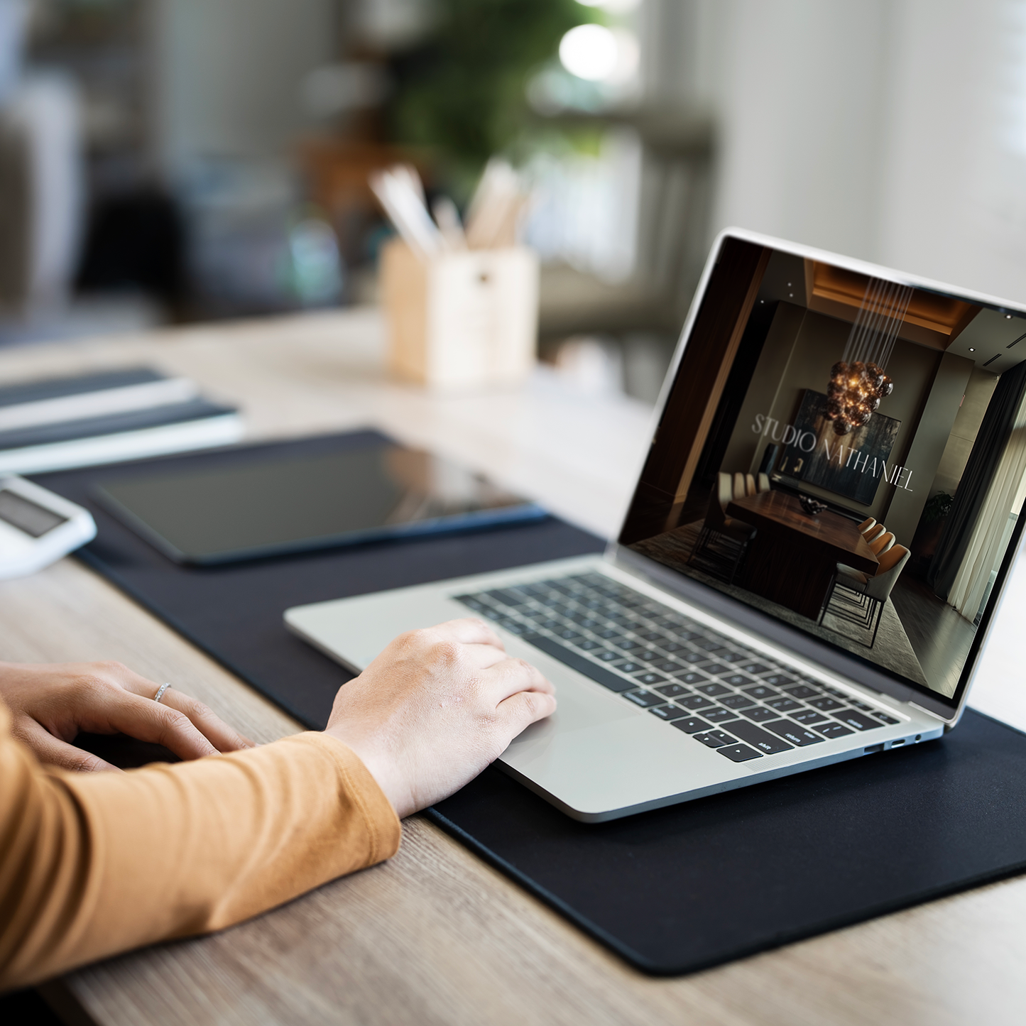 An interior designer working on a laptop with the LSI Workshop Client Experience Guide template. From the Nathaniel Collection. 
